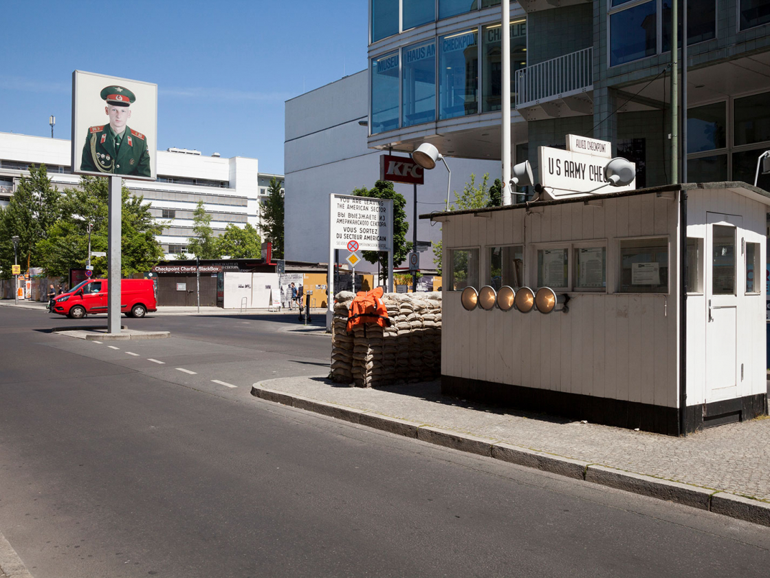 Bild vom Checkpoint Charlie mit Kontrollhäuschen im Vordergrund
