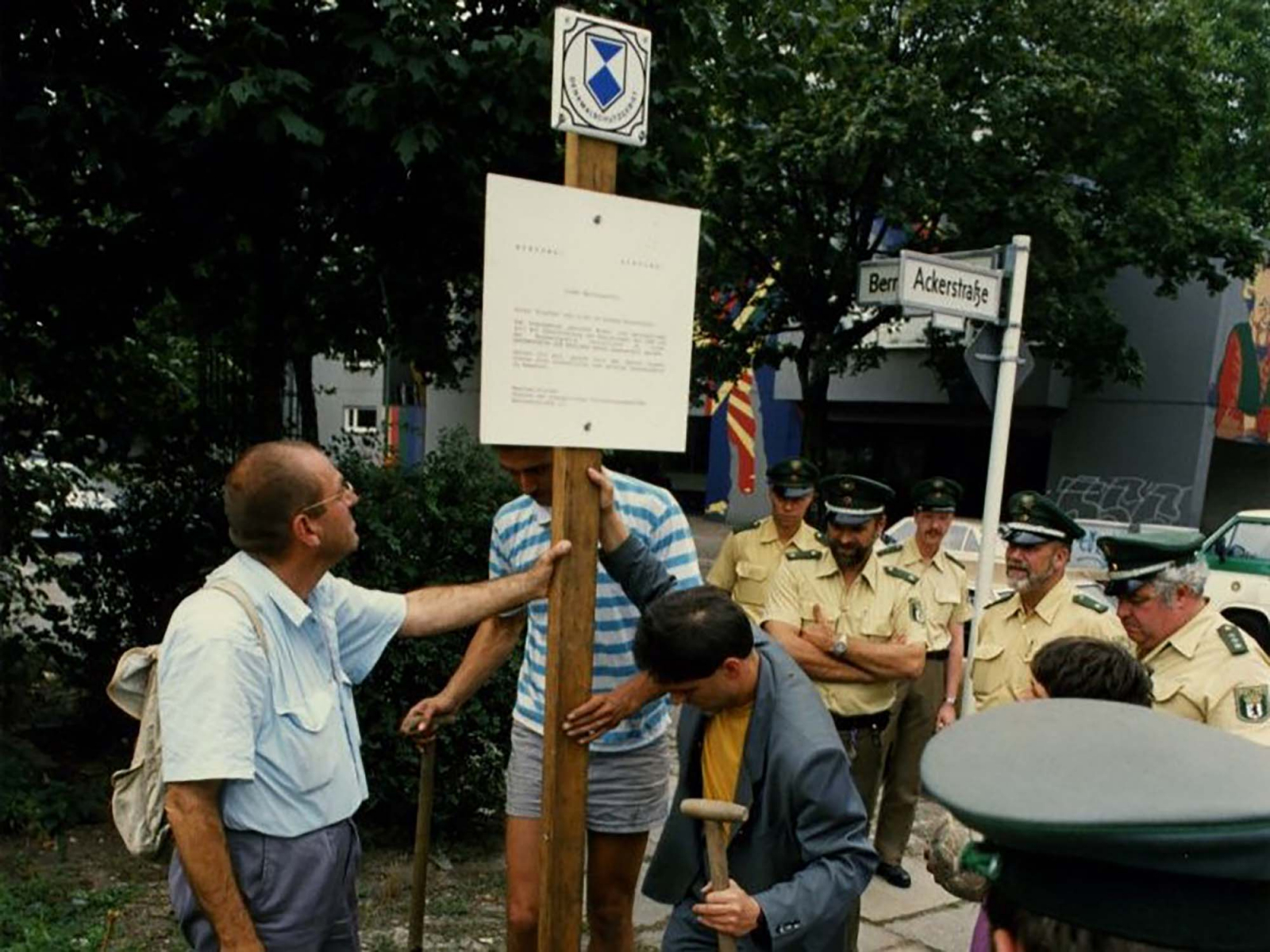 Personen stellen ein Schild auf