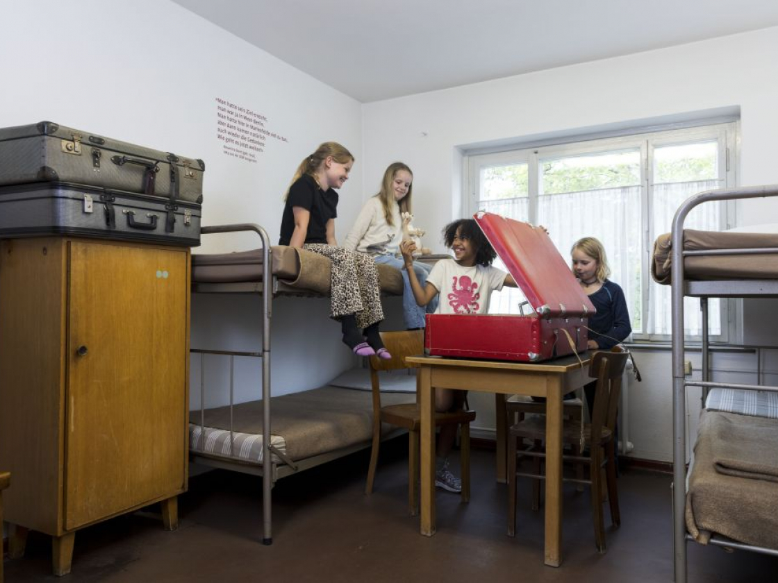 Kinder sind in einem Raum und gucken in einen großen Koffer