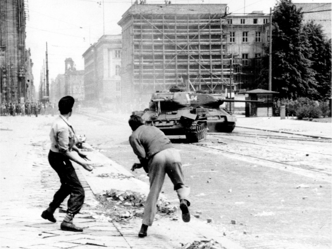 Personen werfen Steine gegen das Militär